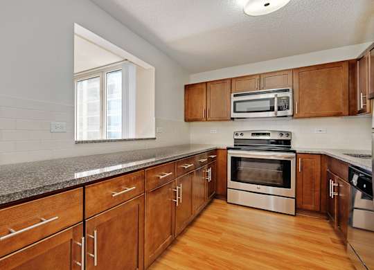 A kitchen with wooden cabinets and stainless steel appliances.