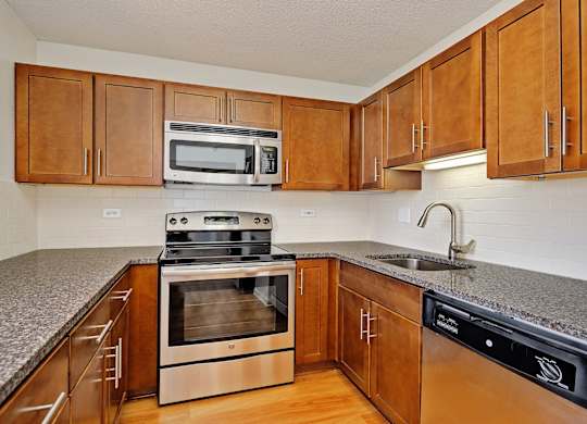 A kitchen with wooden cabinets and a granite countertop.