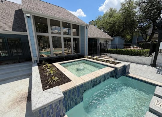 A small pool with a stone border and a concrete floor.