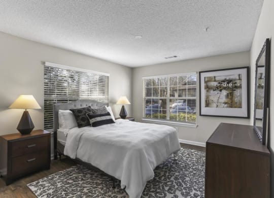 a bedroom with a bed and two windows