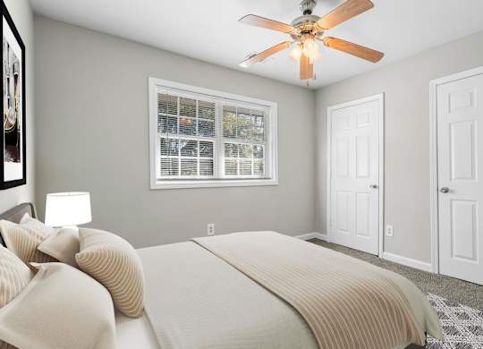a bedroom with a bed and a ceiling fan