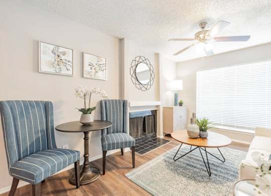 a living room with a fireplace and a ceiling fan