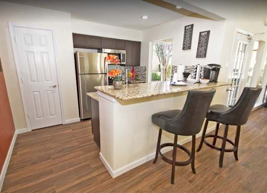 a kitchen with a breakfast bar and a stainless steel refrigerator