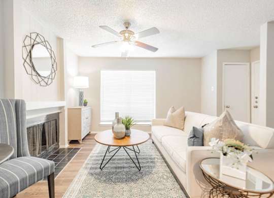 a living room with a fireplace and a ceiling fan