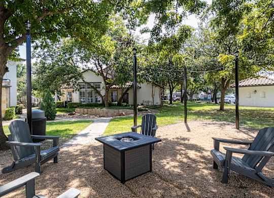 A park with a table and chairs under a tree.