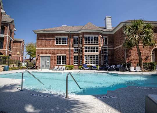 A pool in front of a brick building with a sign that says