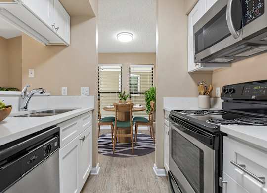 A modern kitchen with a dining table and chairs in the middle.