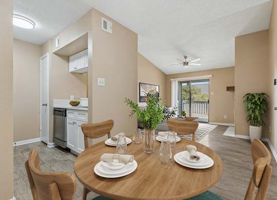 A dining room with a table set for two with a view of the backyard.