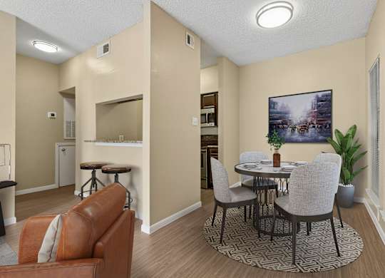 A living room with a brown leather couch and a round table with chairs.