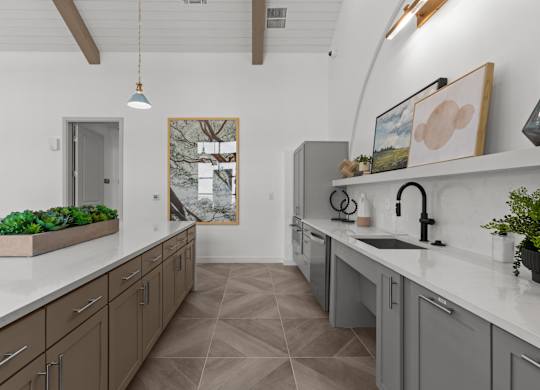 A kitchen with brown cabinets and a large painting on the wall.