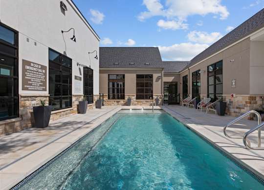A swimming pool in a sunny outdoor setting.