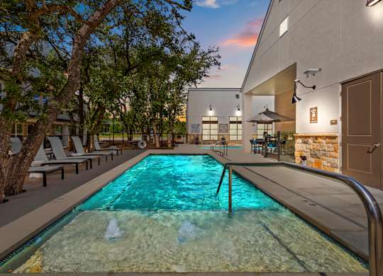 A swimming pool with a metal railing and a waterfall in the middle.
