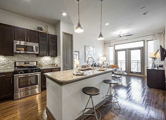 A modern kitchen with dark wood cabinets and a white island.