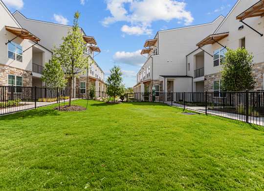 A grassy area in front of a row of houses.