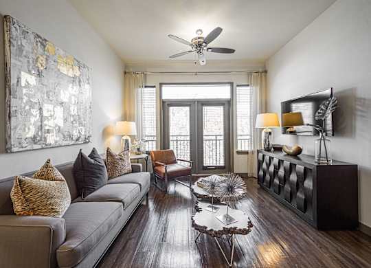 A living room with a grey couch, a coffee table, and a painting on the wall.