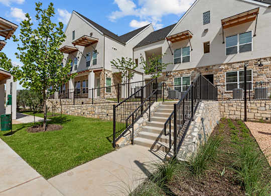 A modern house with a black metal railing on the stairs.