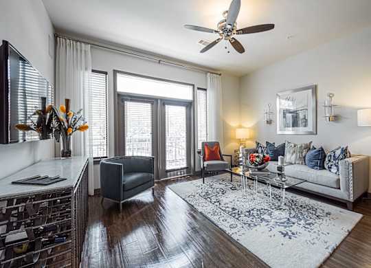 A living room with a grey sofa, a coffee table, and a ceiling fan.