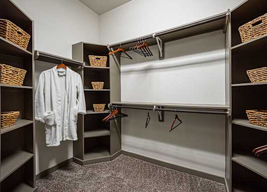 A white shirt is hanging on a hanger in a closet.