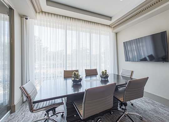 A conference room with a large table and chairs.