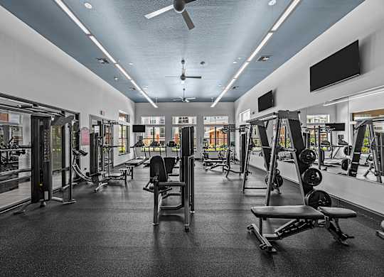 A gym with a variety of equipment including weights and machines.