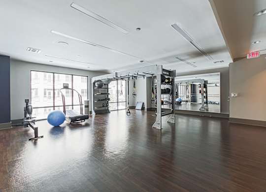 A gym with a blue ball and a mirror on the wall.