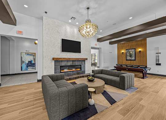 A living room with a grey couch and a fireplace.