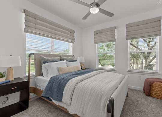 A bedroom with a large bed and a ceiling fan.