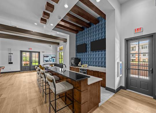 A kitchen with a bar area and chairs.