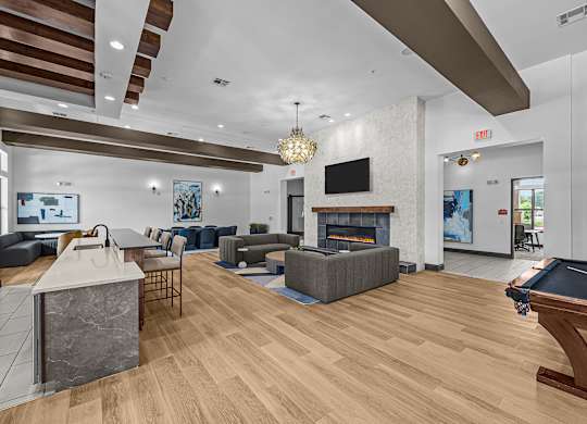 A modern living room with a pool table and a fireplace.