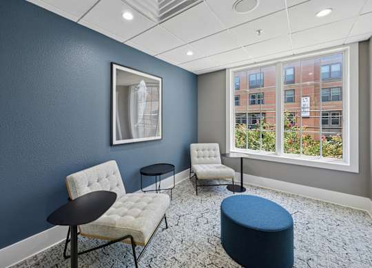 A room with blue walls and a window overlooking a building.