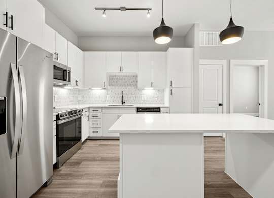 A modern kitchen with white cabinets and a large island.