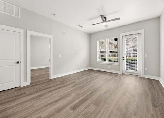 A room with a ceiling fan and a window with blinds.