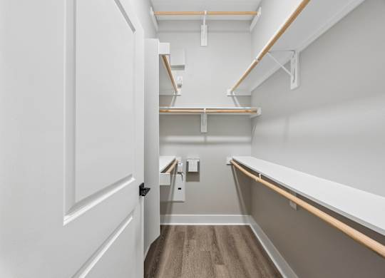 A white door is open to a hallway with a bench and shelves.