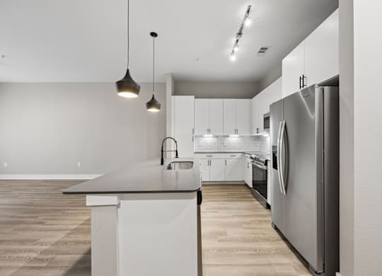 A modern kitchen with a large island and stainless steel appliances.