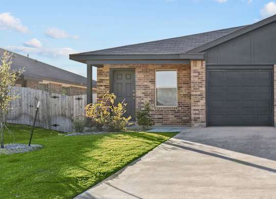 a driveway in front of a house with a garage door