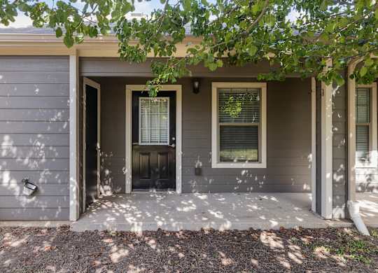the front of a house with a porch and a door