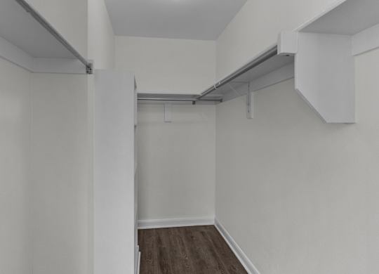 an empty room with white walls and a wood floor