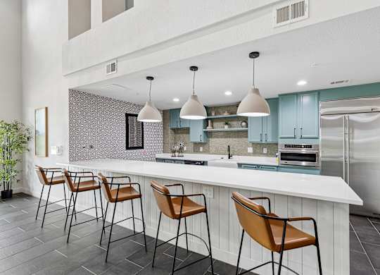 A kitchen with a white counter and brown chairs.