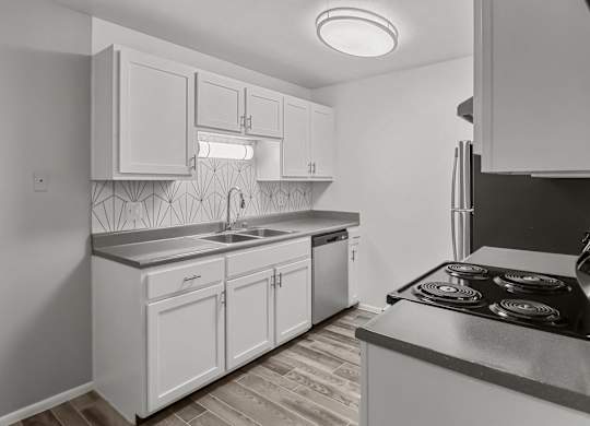 an empty kitchen with white cabinets and stainless steel appliances