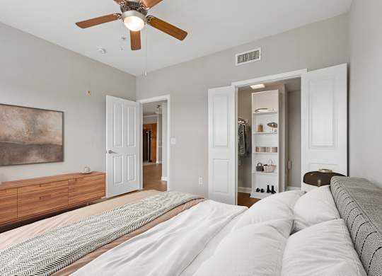 A bedroom with a large bed and a ceiling fan.