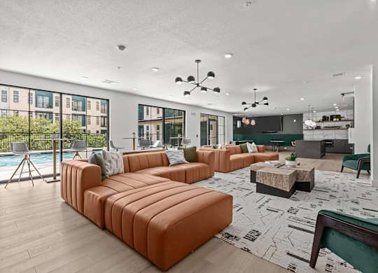 A living room with a pool table and a large orange sofa.