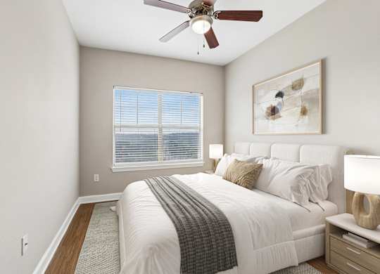 A bedroom with a bed, nightstand, and a ceiling fan.