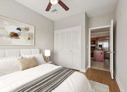 A bedroom with a large bed and a painting on the wall.