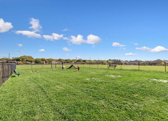 A park with a blue sky and white clouds.