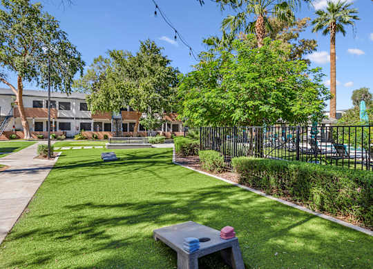 A park with a bench and a fence.