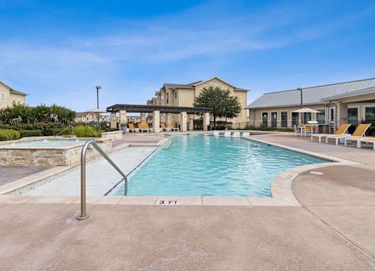 A swimming pool with a metal ladder and a building in the background.