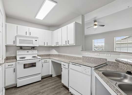 A kitchen with white appliances and cabinets.