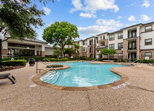 A swimming pool surrounded by apartment buildings.