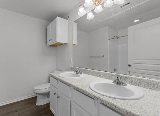 A white bathroom with a toilet, sink, and medicine cabinet.