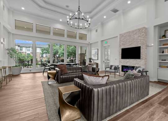 A modern living room with a brown leather couch and a fireplace.